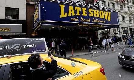 A woman takes a picture of the Ed Sullivan Theatre displaying the Late Show with David Letterman marquee, in New York, New York, USA, 20 May 2015. -- PHOTO: EPA