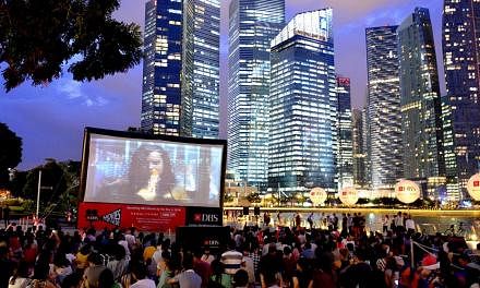 People watching a film during a screening at the DBS Movies by the Bay, a monthly event launched in October 2013. DBS has pledged to pump in another $12 million over the next three years to draw more people to the Marina Bay area, to make it a vibran