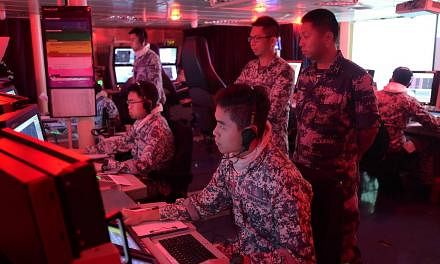 A PLA(N) officer (right, standing) observing the conduct of the Air Defence component of Exercise Maritime Cooperation in the Combat Information Centre of RSS Intrepid. The Republic of Singapore Navy (RSN) and the People's Liberation Army (Navy) (PLA