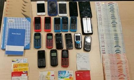 Officers seized about $6,400 in cash, mobile phones, Automated Teller Machine (ATM) cards, banking slips and bank account books. -- PHOTO: SINGAPORE POLICE FORCE