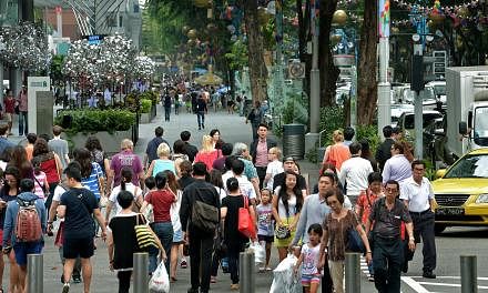 Shoppers along Orchard Road near the junction of Takashimaya. Consumer confidence in Singapore continued to climb in May, with respondents in a survey more upbeat about both their current and future financial state. -- PHOTO: ST FILE