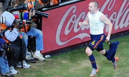 Spain's midfielder Andres Iniesta celebrates after scoring the opening goal during extra-time in the 2010 World Cup football final Netherlands v Spain on July 11, 2010. Adidas, along with Coca-Cola, Hyundai and Kia Motors, Visa, and Russian energy gi