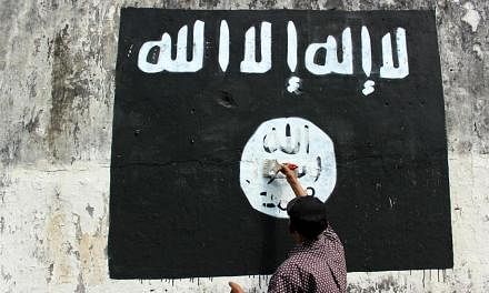 A resident painting over an ISIS flag in Solo, Central Java. The Islamic State in Iraq and Syria (ISIS) has ramped up its activities in South-east Asia so effectively that there is now an entire military unit of terrorists recruited from Indonesia, M