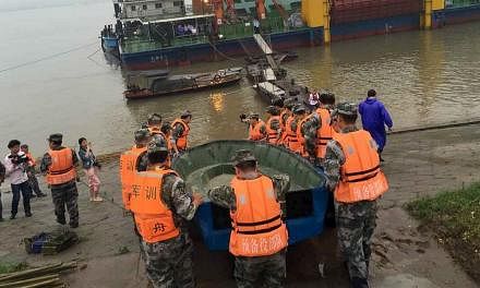 Rescue workers carrying a boat to conduct a search after a ship sank at the Jianli section of Yangtze River, Hubei province, on June 2, 2015. -- PHOTO: REUTERS