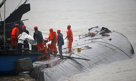 Rescue workers carry a body from a sunken ship in the Jianli section of Yangtze River, Hubei province, China, on June 2, 2015. The sinking of the cruise boat is likely to mar the country's generally clean maritime safety record, which hasn't suffered