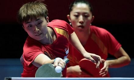 Singapore paddlers Feng Tianwei (left) and Yu Mengyu in action during the SEA Games' women's doubles competition at the Singapore Indoor Stadium on June 1, 2015. -- PHOTO: REUTERS
