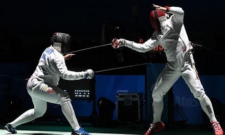 Malaysia's Mohamad Roslan Mohamed (left) competes with Singapore's Lim Wei Wen (right) in their men's individual epee round of 16 fencing match during the 28th Southeast Asian Games (SEA Games) in Singapore on June 3, 2015. -- PHOTO: AFP