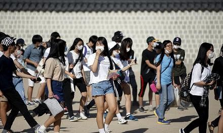 South Korean students wearing masks to prevent contracting Middle East Respiratory Syndrome (MERS) as they walk at the Gyeongbok Palace in central Seoul, South Korea on June 3, 2015. -- PHOTO: REUTERS&nbsp;