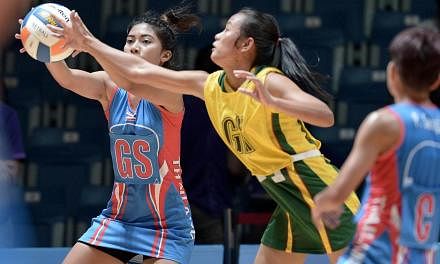 Thailand's Yada Boonkong (left) competes with Myanmar Mon Khin Aye (centre) during the women's netball preliminary round between Thailand and Myanmar at the 28th SEAgames 2015 in Singapore on June 3, 2015. -- PHOTO: AFP