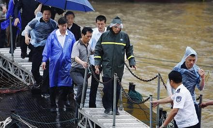 Chinese Premier Li Keqiang (centre) inspects the rescue efforts of the capsized tourist ship in the Yangtze River in Jianli county, Hubei province, China on June 3, 2015. -- PHOTO: EPA