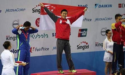 Singapore swimmer Quah Zheng Wen celebrating on the podium after his record-breaking SEA Games gold in the men's 100m backstroke on June 6, 2015. -- ST PHOTO: WANG HUI FEN&nbsp;