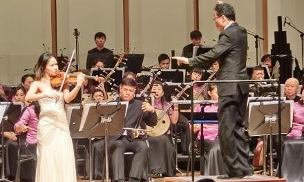 Violinist Kam Ning (left) performing with the Singapore Chinese Orchestra, conducted by Yeh Tsung. -- PHOTO: CHANG TOU LIANG