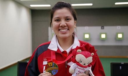 Singapore shooter Teo Shun Xie holding up her SEA Games gold medal in the women's individual 10m air pistol event on June 7, 2015. -- PHOTO: SINGAPORE SEA GAMES ORGANISING COMMITTEE/ACTION IMAGES VIA REUTERS