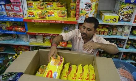 An Indian shopkeeper removes packets of Nestle Maggi instant noodles from the shelves in his shop in Siliguri on June 5, 2015. India's food safety regulator on June 5 banned the sale and production of Nestle's Maggi instant noodles over a health scar