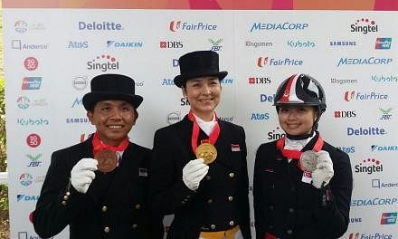 Indonesia's top dressage rider Gading Larasati (centre) with her SEA Games gold medal in the individual dressage event on June 9, 2015. Singapore's Caroline Chew (right) claimed silver while Gading's compatriot Menayang Alfaro (left) got the bronze. 
