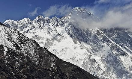 A view of Mount Everest (background) towering over the Nupse-Lohtse massif (foreground) from the village of Tembuche in the Khumbu region of north-eastern Nepal on April 20, 2015. -- PHOTO: AFP