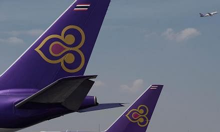 A Thai Airways aircraft takes off past the tails of two other Thai Airways planes at Bangkok's Suvarnabhumi international airport in a November 2014 file photo.&nbsp;Authorities at Lahore airport in Pakistan arrested four men suspected of trying to s