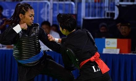 Nur Shafiqa Sheik Alau'ddin of Singapore (left) competes against Olathay Sounthavong of Laos during their women's pencak silat semi-final tanding class B (50-55kg) match at the 28th Southeast Asian Games (SEA Games) in Singapore on June 13, 2015. -- 