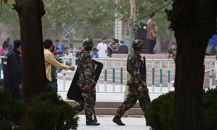 Paramilitary police patrolling beside the central square in Hotan, in China's western Xinjiang region, on April 16, 2015.&nbsp;Some local governments in China's unruly far western region of Xinjiang are stepping up controls on the Islamic faith follo