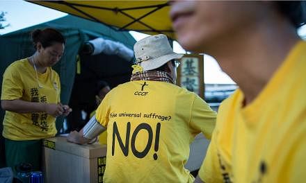 A protester wears a t-shirt against "fake universal suffrage" in a makeshift tent outside the Legislative Council in Hong Kong, China, on June 15, 2015. Hong Kong's Legislative Council (LegCo) will this week debate and vote on a bill on electoral ref