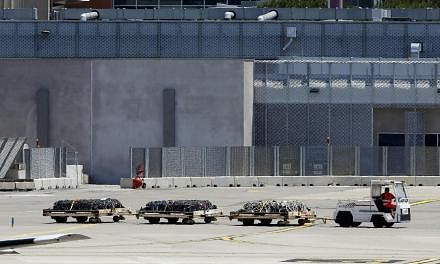 An airport vehicle pulls three cargo platforms with coffins on the tarmac at the Marseille Provence Airport in Marignane, France on Monday as Lufthansa prepares to transport coffins with the remains of 30 victims of the Germanwings Airbus A320 crash 