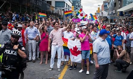 Canadian PM Justin Trudeau (middle, in pink shirt and white trousers) marching in the Pride Festival parade on July 3, 2016 in Toronto.