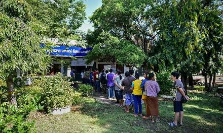 Thai PM Prayut Chan-o-cha (top) and former prime minister Yingluck Shinawatra (above) casting their vote in Bangkok. People queuing at a polling station in Thailand's north-eastern province of Buriram yesterday to vote in the country's constitutional