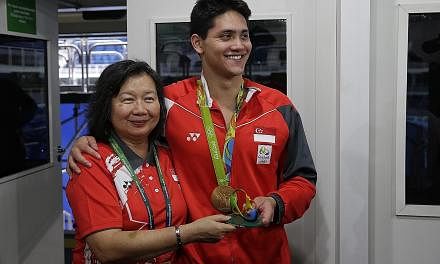 Above: Joseph Schooling with his mother May after winning the men's 100m butterfly final in Brazil yesterday. Right: His father, Colin (seated second from right), celebrating with family and friends during the live telecast of the race.