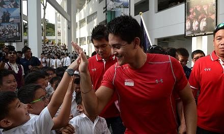 2012 Olympic gold medallist Chad le Clos advises Schooling not to let people change him. "Just stay true to yourself, to your family," he says. Schooling giving an Anglo-Chinese School (Junior) pupil a high-five during a visit to the school last week