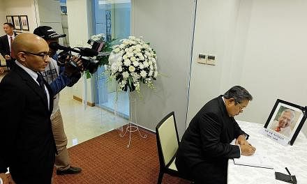 Dr Yudhoyono signing the condolence book for Mr Nathan at the Singapore Embassy in Jakarta yesterday as Singapore's Ambassador to Indonesia Anil Kumar Nayar looked on.