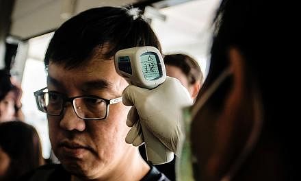 A health official at Yogyakarta airport checking the temperature of a passenger arriving from Singapore on Sept 2, after Zika cases were reported in the Republic.