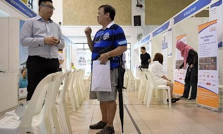 Mr Teo (right), who lost his Peranakan food stall, was at the job fair at Jurong Green Community Club yesterday. Mr Teo plans to take a vocational course to upgrade his hawker skills and is considering a part-time job.
