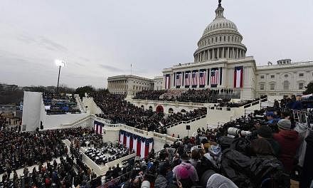 Democratic presidential nominee Hillary Clinton and her husband, former president Bill Clinton, arriving for the inauguration ceremony of Mr Trump yesterday. The West Front of the US Capitol in Washington filling up with guests prior to the swearing-