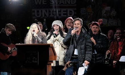 Celebrities (front row, from left) Natalie Merchant, Cher and Mark Ruffalo at the We Stand United NYC Rally outside Trump International Hotel on Thursday night in New York City.