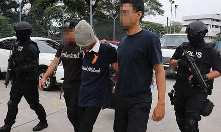 An alleged militant being led away by Malaysian police after a raid last month. The four Yemeni suspects behind a planned attack were nabbed in these operations.