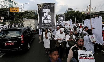 Hardline Muslims protesting in front of the Supreme Court in Jakarta yesterday to call for maximum punishment for Jakarta Governor Basuki Tjahaja Purnama (above), ahead of the verdict of a blasphemy trial next week.