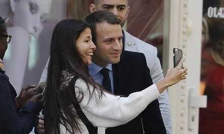 Mr Emmanuel Macron in a selfie moment with a delighted supporter after he defeated Ms Marine Le Pen in Sunday's French presidential election.
