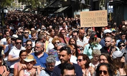 People observing a minute of silence at the Las Ramblas boulevard in Barcelona as they gathered to pay tribute to victims of Thursday's van attack which killed 13 and injured more than 100. The area is a popular tourist destination, so many of the vi