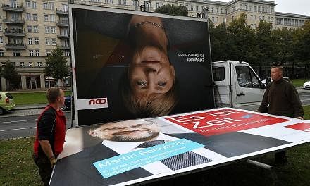 Workers removing campaign billboards for Germany's election which saw Chancellor Angela Merkel winning a fourth term but without a majority in Parliament on Sunday. The rise of the far-right Alternative for Germany party and its entry to Parliament a