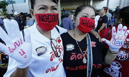 Supporters of former Thai prime minister Yingluck Shinawatra in front of the Supreme Court yesterday expressing their love for the ousted leader. The court found her guilty of negligence over her government's rice subsidy scheme, which is said to hav