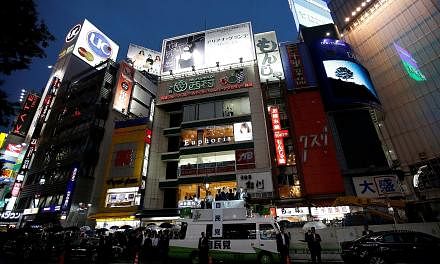 Japanese Prime Minister Shinzo Abe, who is also leader of the ruling Liberal Democratic Party, delivering a speech on top of a campaign van in Tokyo's Shibuya district yesterday. His trademark Abenomics policy has helped Japan stave off deflation but