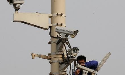 A man working on a security camera in Tiananmen Square. China's anti-corruption campaign to "kill tigers and swat flies" - or to go after both senior officials and the rank and file - seems set to continue.