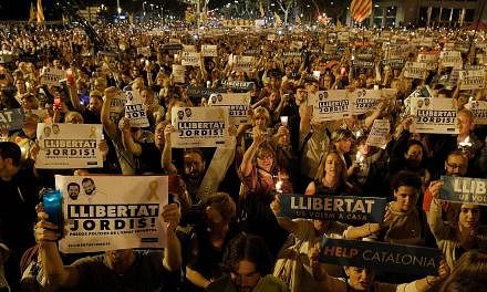 Catalans with placards reading "freedom" during a demonstration in Barcelona on Tuesday night against the arrest of two separatist leaders.