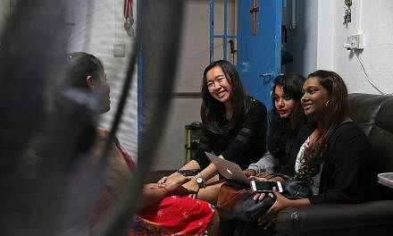 Temasek Polytechnic students (from right) Vishnupriya Raja Mohan, 17, Belinda Abraham, 18, and Megan Tan, 17, speaking to a single mother to understand her situation better. They have put the information in an advocacy report, which will be sent to a
