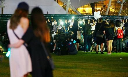 The mood at Hong Lim Park was sombre as many fans hugged and cried. They waved light sticks and smartphones in the air as they sang in unison to the SHINee song Replay.