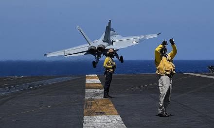 Sailors on flight deck duty as an FA-18 hornet fighter jet took off during routine training aboard US aircraft carrier Theodore Roosevelt in the South China Sea in April. As defence officials gather to discuss some of the Indo-Pacific's most pressing