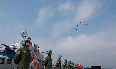 People's Liberation Army Navy personnel taking part in a military display in the South China Sea in April. Beijing has pointed the finger squarely at US Fonops in the South China Sea as the trigger for China to deploy "necessary defence" of its claim