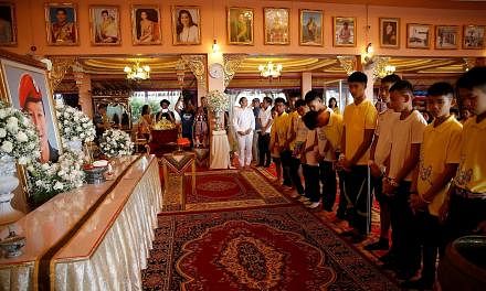 Some of the boys rescued from the Tham Luang cave complex paying their respects to former navy Seal diver Saman Gunan, who lost his life during the rescue operation, at Mae Sai's Wat Pha That Doi Wao temple in Chiang Rai province yesterday.