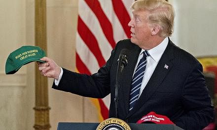President Donald Trump with a "Make Our Farmers Great Again" cap while speaking at a Made in America products showcase in the Cross Hall of the White House on Monday.