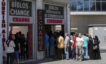 A currency exchange office in Istanbul, Turkey, yesterday. Turkey's lira rebounded yesterday from record lows after the central bank pledged to provide liquidity and cut reserve requirements for banks, but the currency was still down around 10 per ce